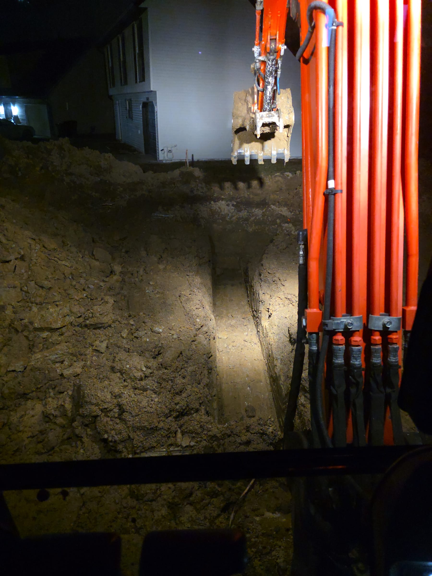 Excavator continuing the footer trench beside the house footprint