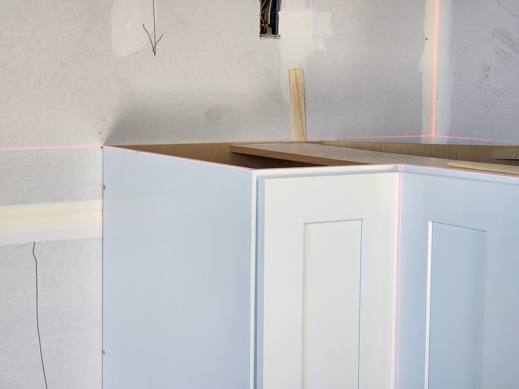 Close view of a base cabinet aligned to the laser reference line