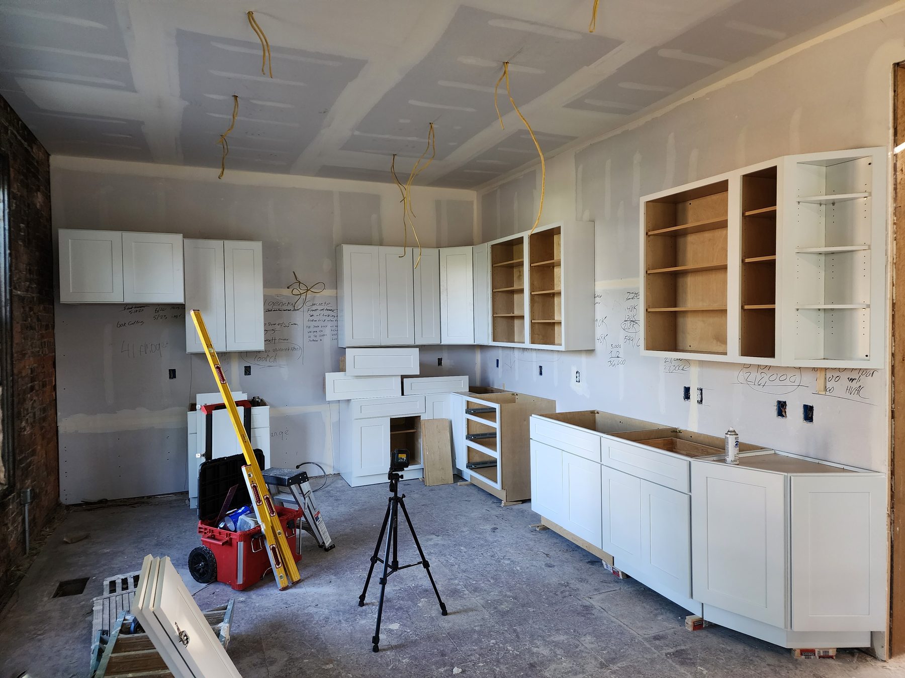 Wide view of white shaker cabinets during installation