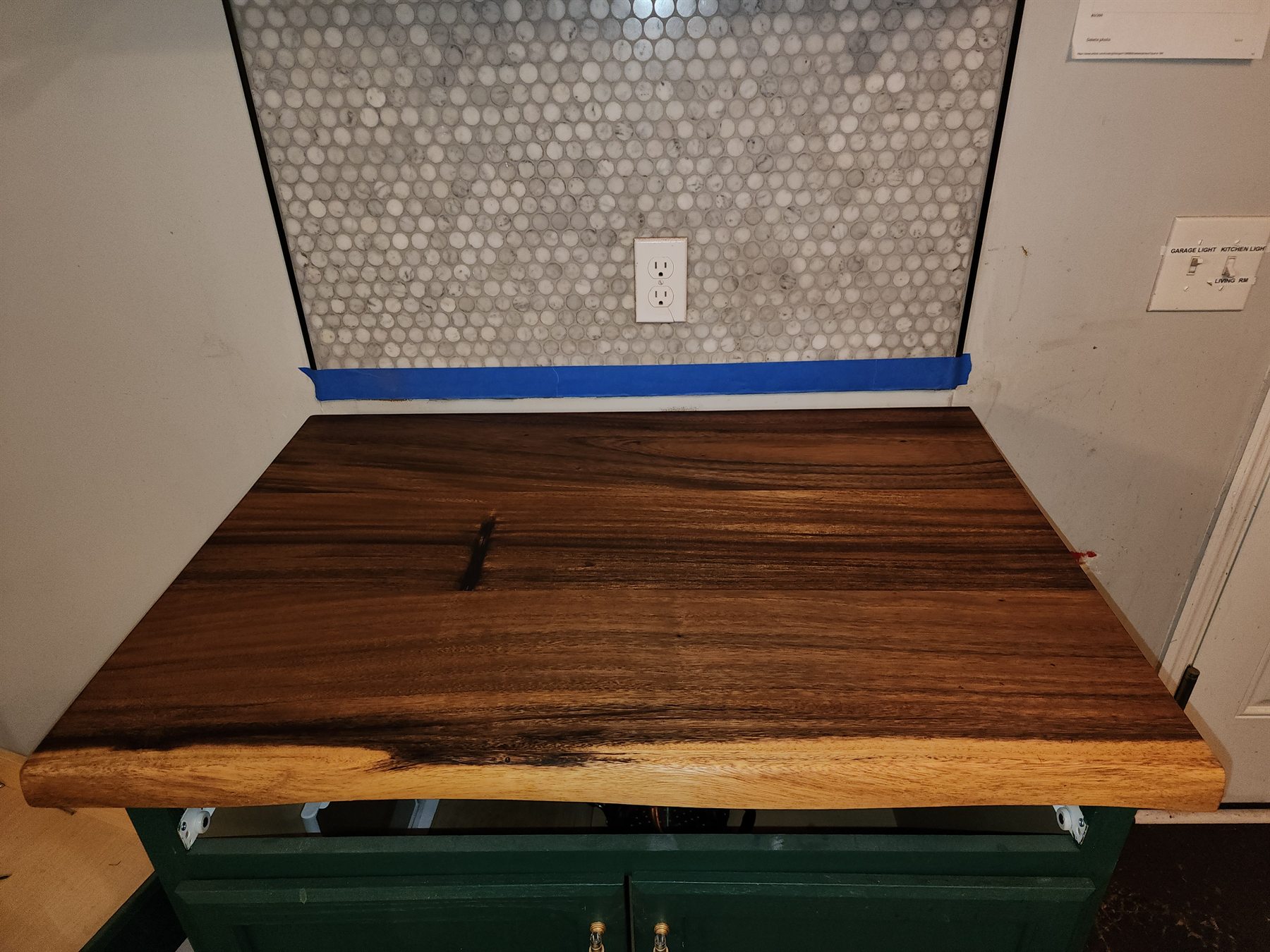 Original live-edge countertop installed beneath a round-tile backsplash