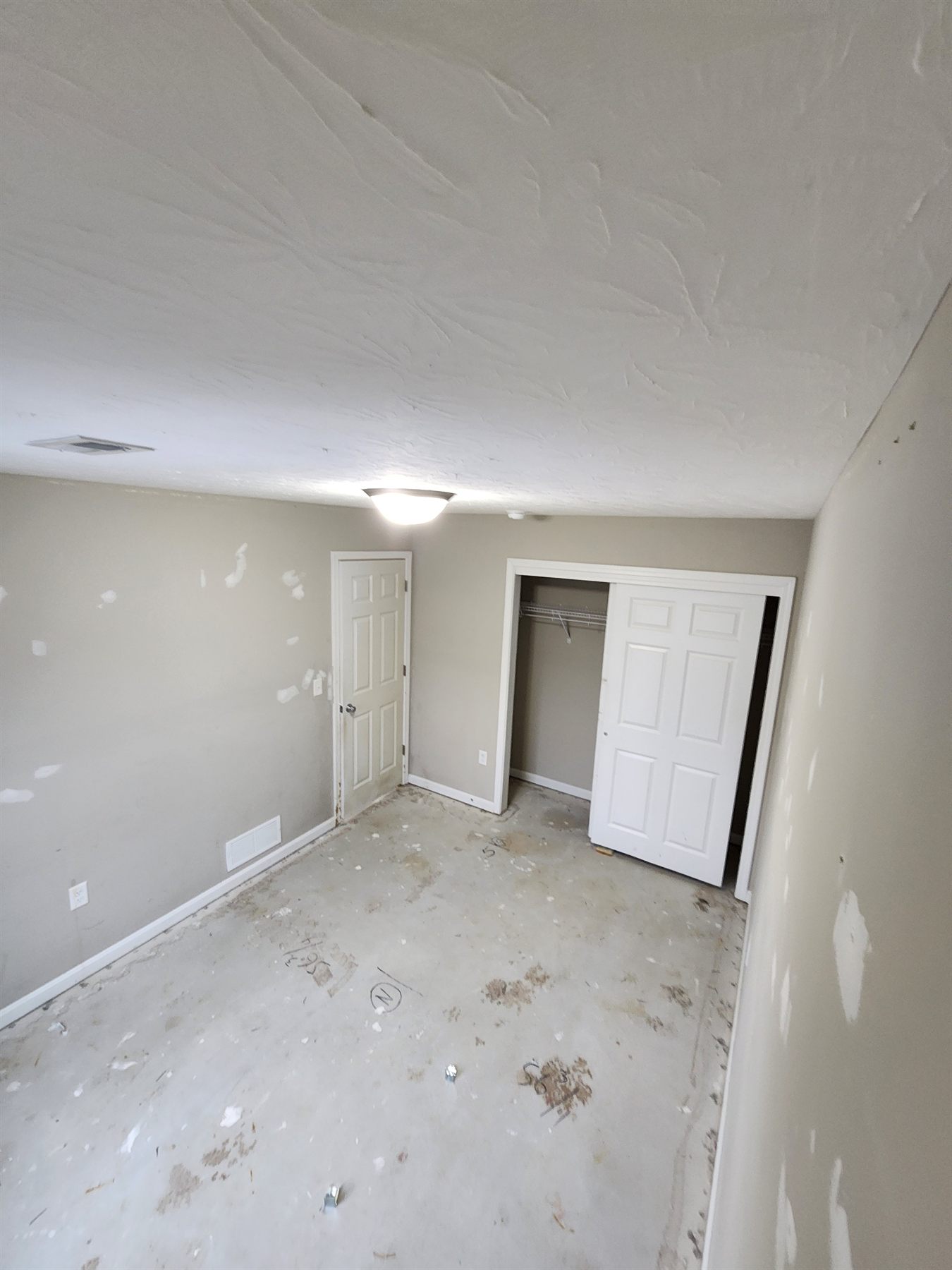 Cleared room with patched walls and exposed floor