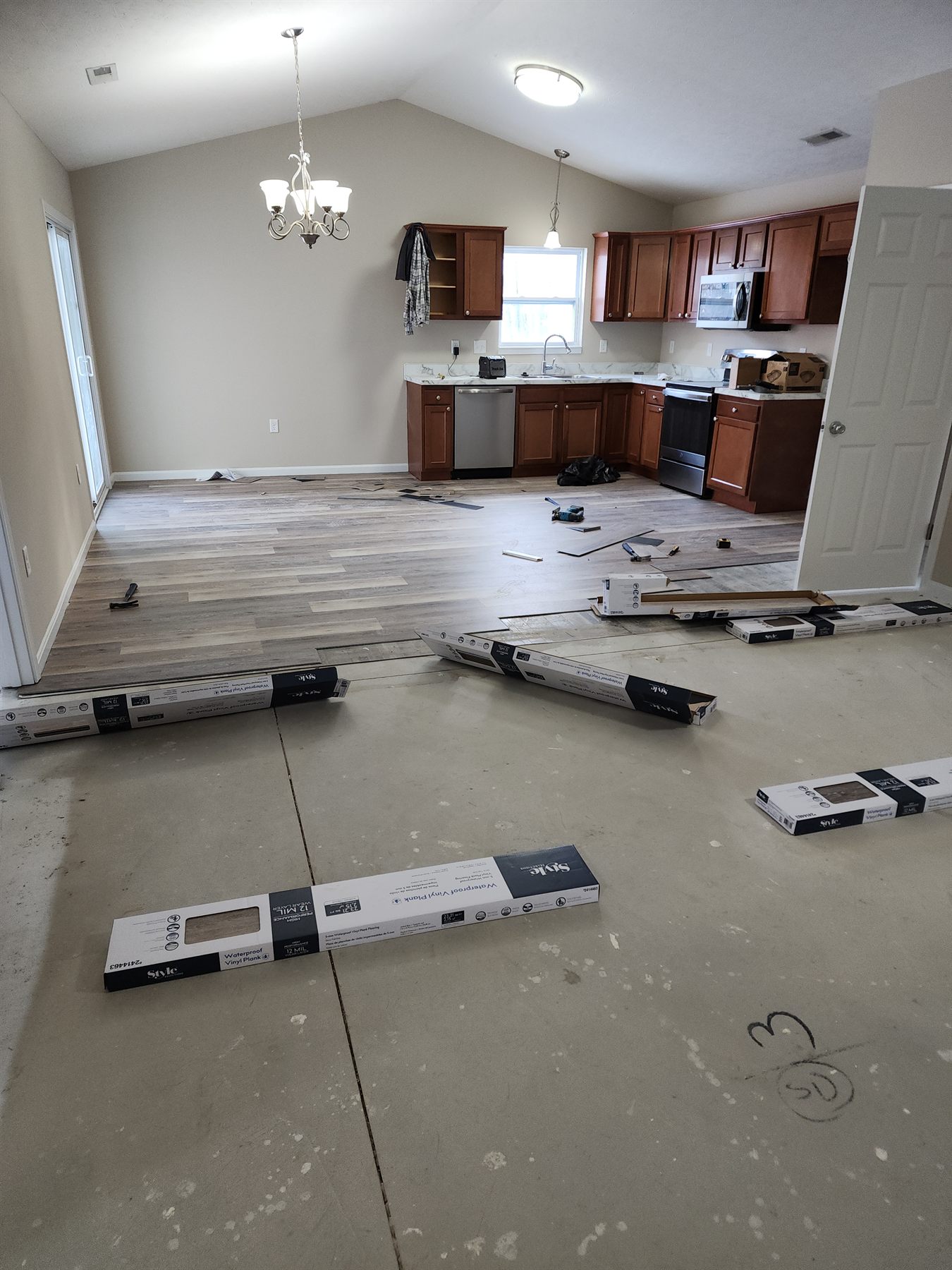 Luxury vinyl plank being installed through the kitchen and living area
