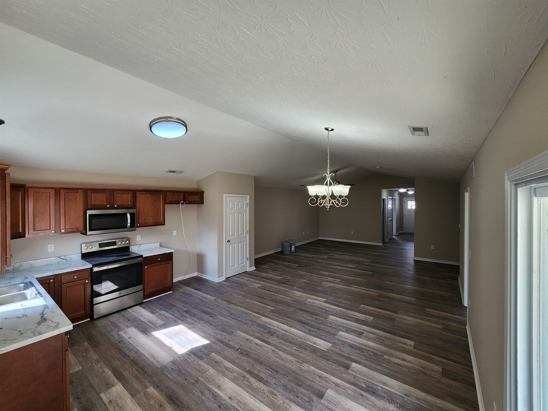 Finished kitchen and main living area with continuous LVP flooring